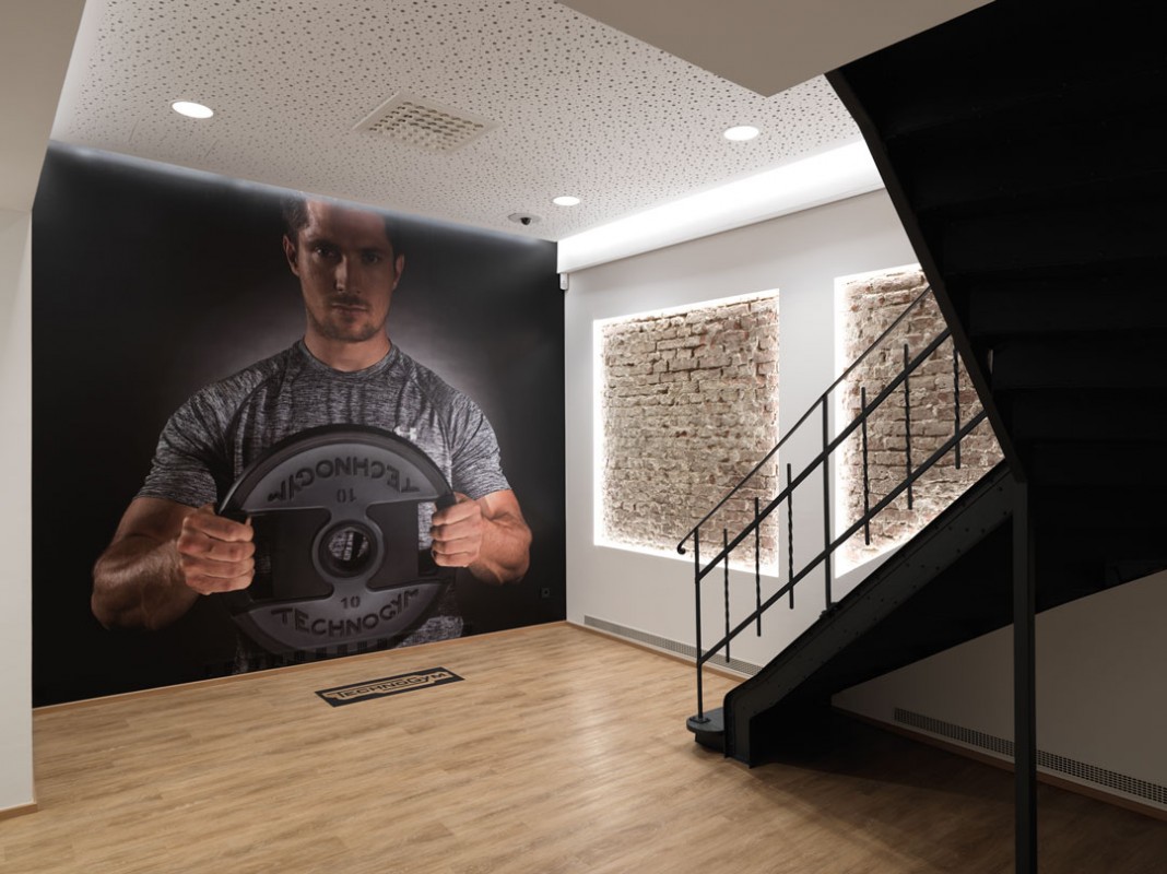 The Fitness Company Wien Innenraum mit grossem Wandbild eines trainierenden Mannes